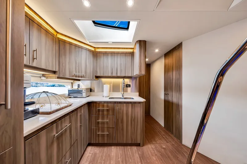 Slide: The Image of Luxurious kitchen interior of 2017 Regal 53 Sport Coupe yacht with modern wood cabinetry. - 79
