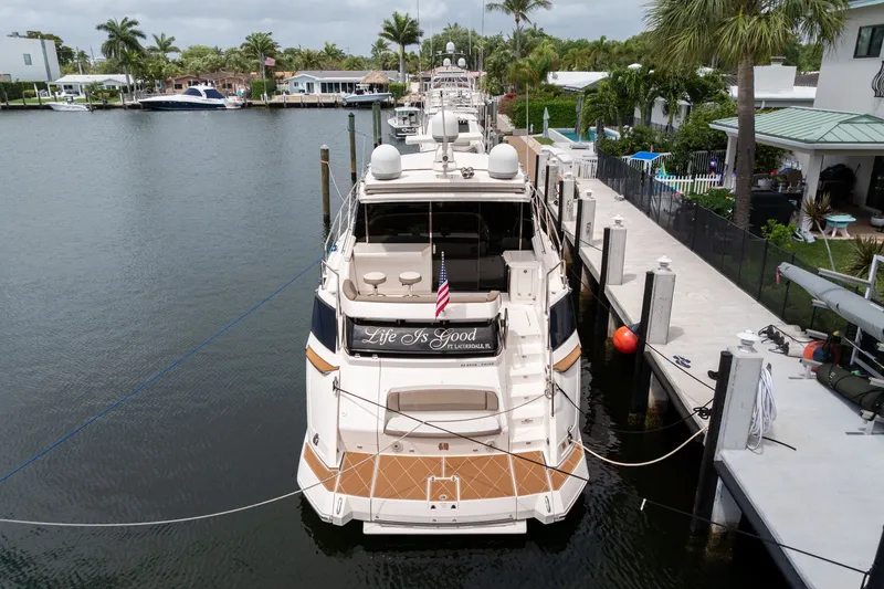 Slide: The Image of 2017 Regal 53 Sport Coupe yacht docked in a scenic waterfront location. - 16