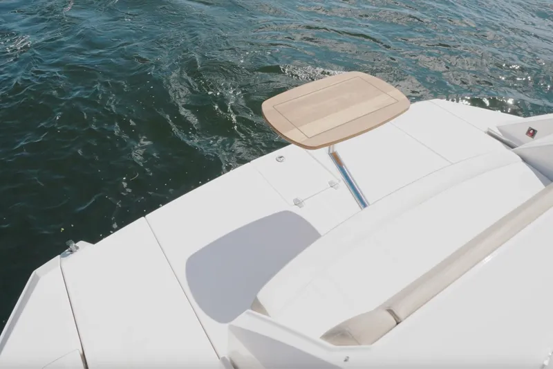 Slide: The Image of 2017 Regal 53 Sport Coupe yacht deck with table, overlooking water. - 6