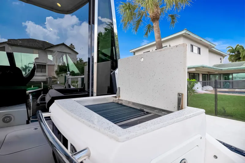 Slide: The Image of 2017 Regal 53 Sport Coupe yacht with outdoor grill, set against a luxurious residential backdrop. - 35