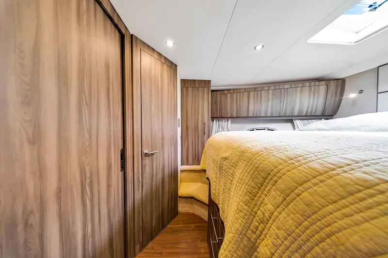 Slide: The Image of Luxurious interior of 2017 Regal 53 Sport Coupe with wood paneling and cozy bedding. - 61