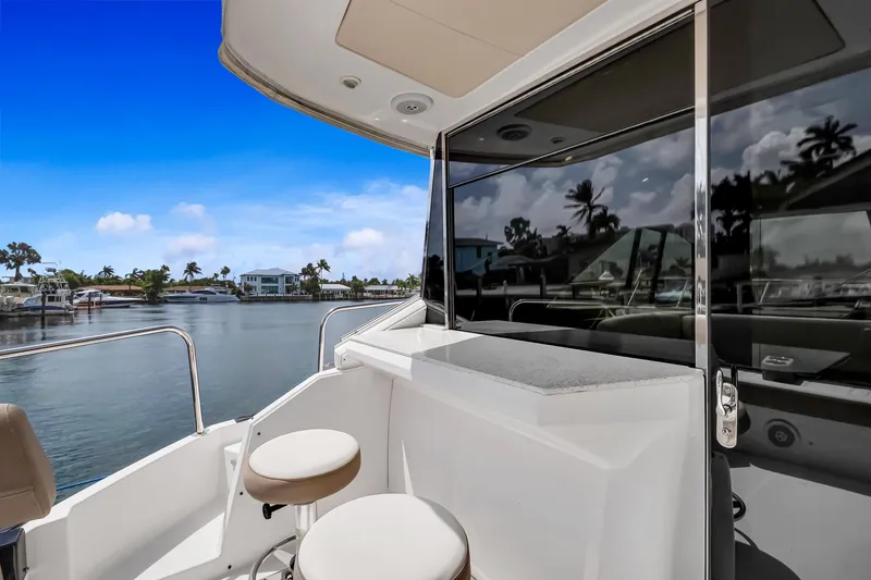 Slide: The Image of 2017 Regal 53 Sport Coupe yacht with sleek design, docked by serene waterfront. - 31