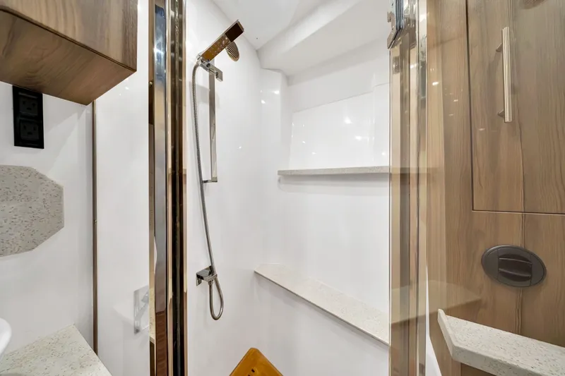 Slide: The Image of Luxurious shower area in 2017 Regal 53 Sport Coupe yacht, featuring modern fixtures and wood accents. - 60