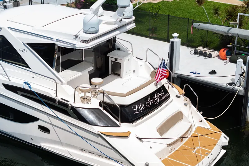 Slide: The Image of 2017 Regal 53 Sport Coupe yacht docked, featuring "Life Is Good" text and American flag. - 25