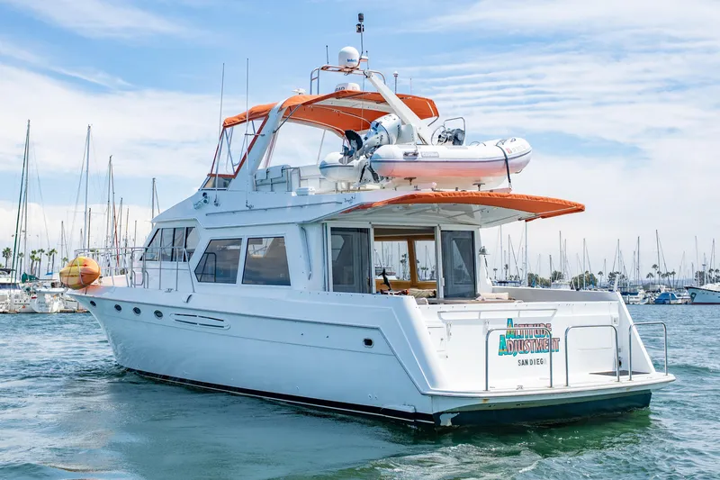 Slide: The Image of 2000 Navigator 5300 Classic yacht in marina, featuring orange canopy and inflatable boat on deck. - 11
