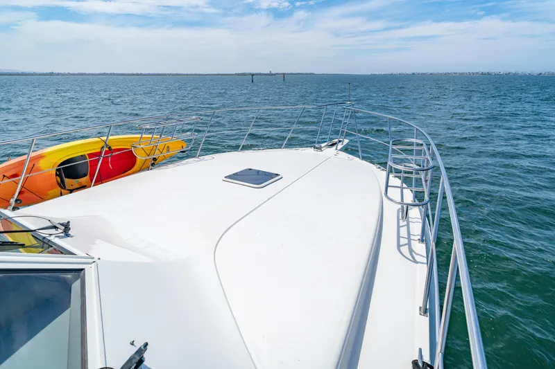 Slide: The Image of Bow of 2000 Navigator 5300 Classic yacht with kayak, on open water under blue sky. - 26