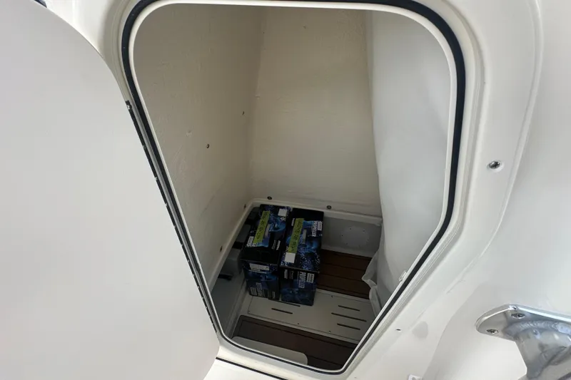 Slide: The Image of Storage compartment inside 2026 Bulls Bay 255 CC boat, featuring marine batteries. - 12