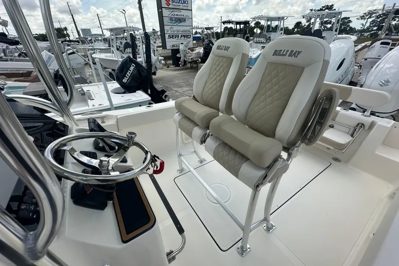 Slide: The Image of 2026 Bulls Bay 255 CC boat interior with dual seats and steering wheel. - 13