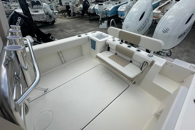 Slide: The Image of 2026 Bulls Bay 255 CC boat interior with seating and Suzuki engines in a marina. - 14