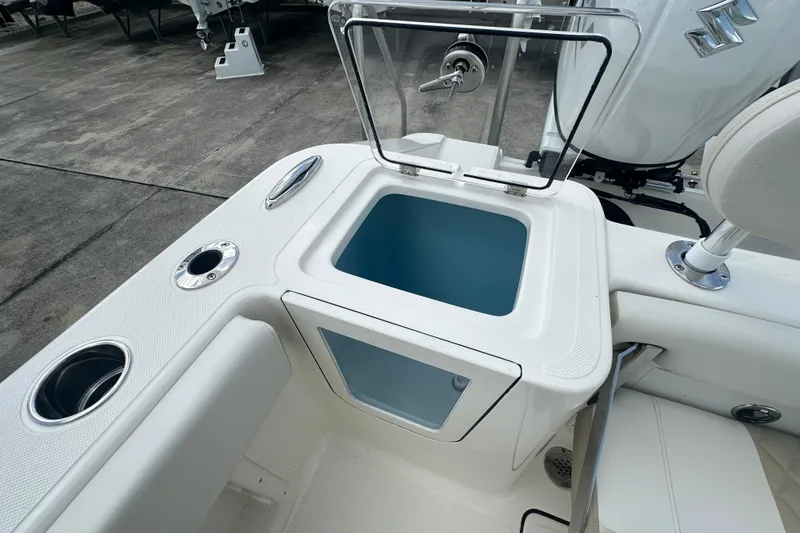 Slide: The Image of 2026 Bulls Bay 255 CC boat interior with open storage compartment and cup holders. - 15