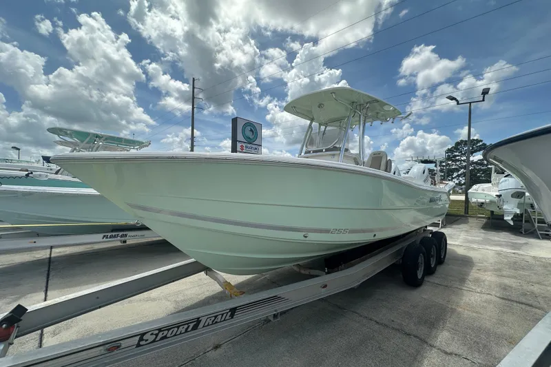 Slide: The Image of 2026 Bulls Bay 255 CC boat on trailer under cloudy sky at dealership. - 2