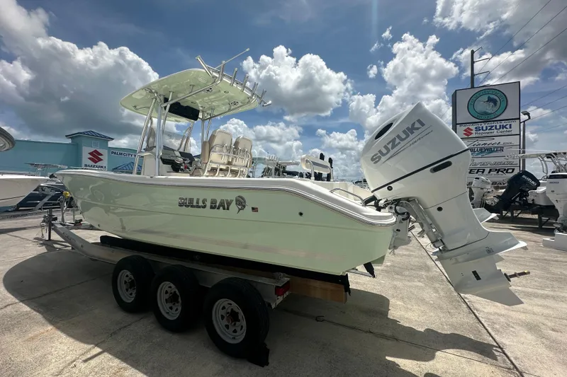 Slide: The Image of 2026 Bulls Bay 255 CC boat with Suzuki engine on trailer under cloudy sky. - 3