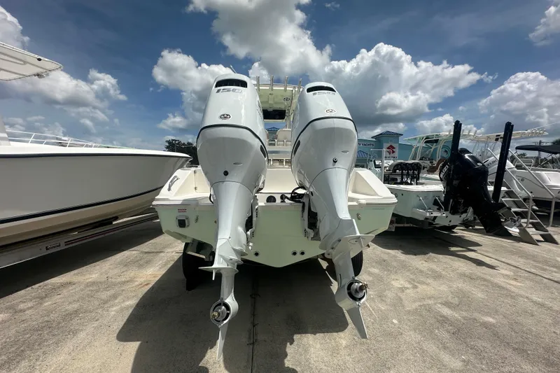 Slide: The Image of 2026 Bulls Bay 255 CC boat with dual outboard engines, parked on a sunny day. - 4