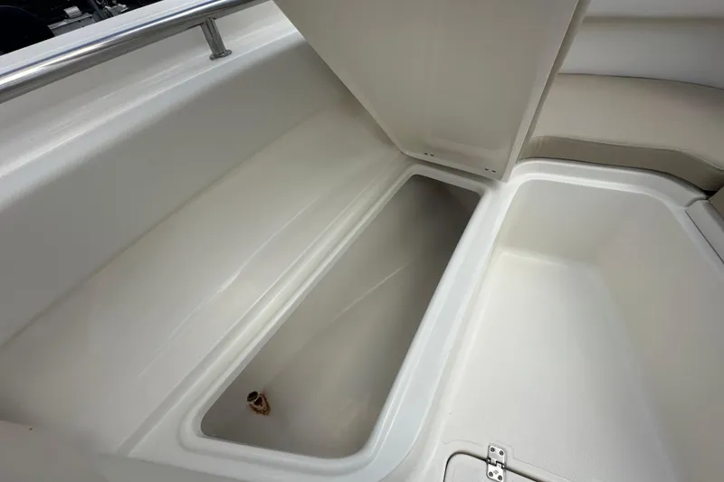 Slide: The Image of 2026 Bulls Bay 255 CC boat storage compartment with open lid, showcasing spacious interior. - 9