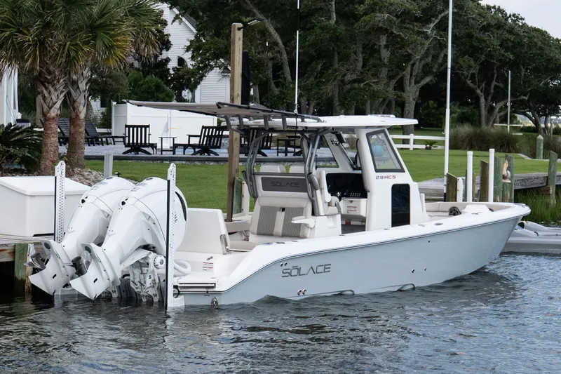 Slide: The Image of 2026 Solace 28 HCS boat docked by lush greenery and waterfront. - 10