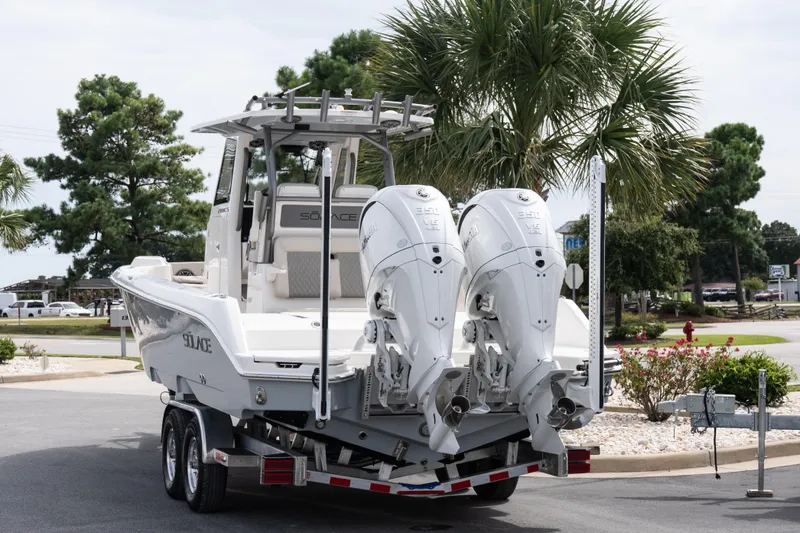 Slide: The Image of 2026 Solace 28 HCS boat on trailer with dual engines, parked near palm trees. - 18