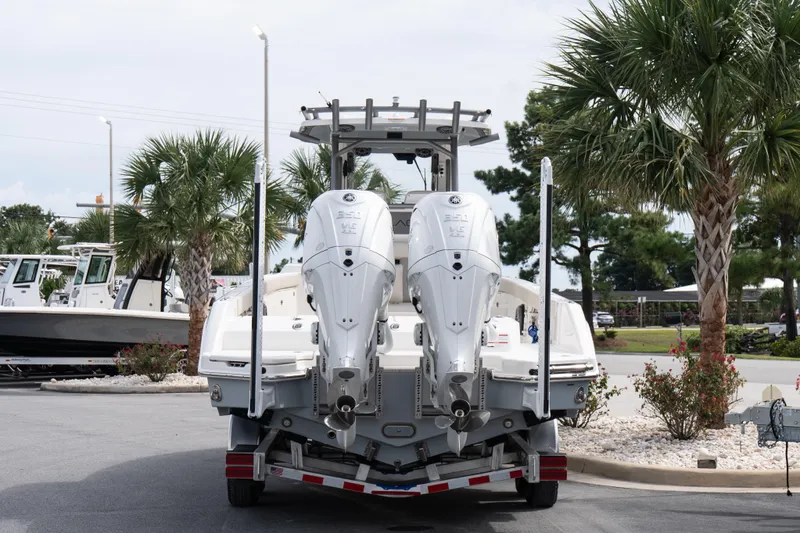 Slide: The Image of 2026 Solace 28 HCS boat with dual engines on a trailer, surrounded by palm trees. - 19