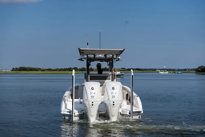Slide: The Image of 2026 Solace 28 HCS boat cruising on a calm lake under a clear blue sky. - 2