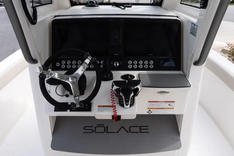 Slide: The Image of 2026 Solace 28 HCS boat dashboard with steering wheel and control panel. - 27