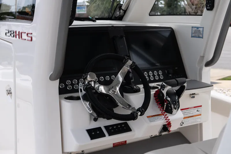 Slide: The Image of 2026 Solace 28 HCS boat dashboard with steering wheel and control panel. - 29