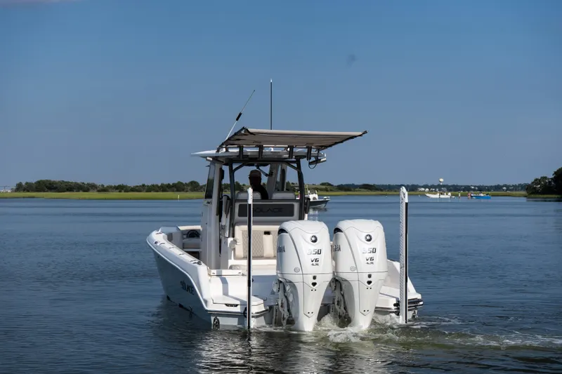 Slide: The Image of 2026 Solace 28 HCS boat with dual engines cruising on a calm lake. - 3