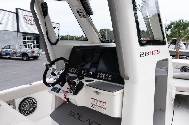Slide: The Image of 2026 Solace 28 HCS boat dashboard with steering wheel and control panel. - 30