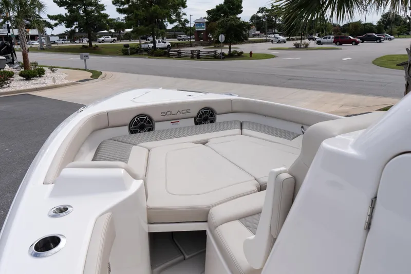 Slide: The Image of 2026 Solace 28 HCS boat interior with cushioned seating and speakers, parked near a road. - 33