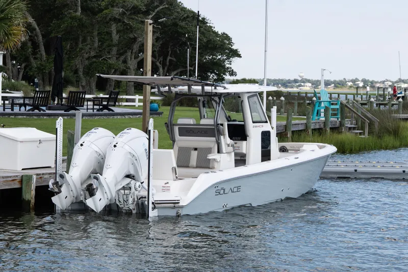 Slide: The Image of 2026 Solace 28 HCS boat docked with dual engines, scenic waterfront background. - 9