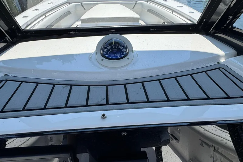 Slide: The Image of 2021 Tidewater 272 CC Adventure boat dashboard with compass and sleek design. - 10