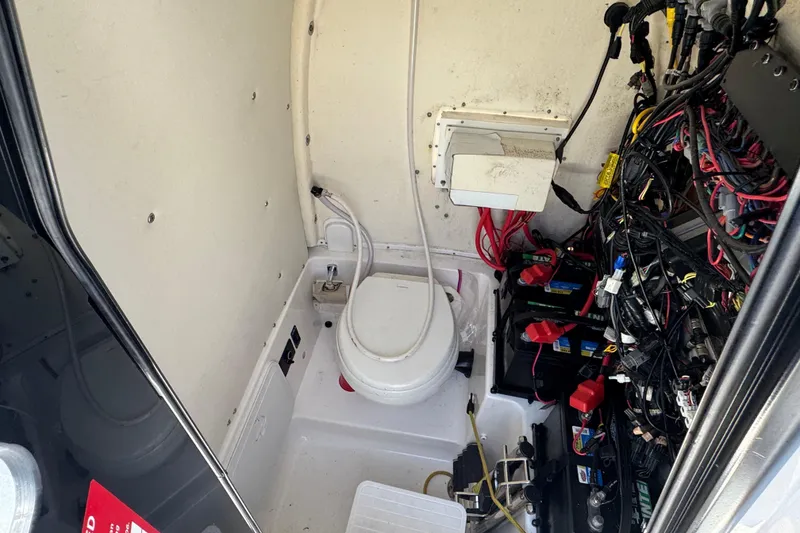 Slide: The Image of 2021 Tidewater 272 CC Adventure boat interior with wiring and marine toilet. - 18