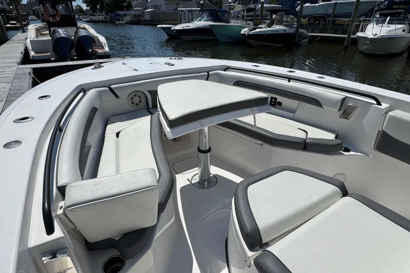 Slide: The Image of 2021 Tidewater 272 CC Adventure boat interior with seating and table, docked at marina. - 20