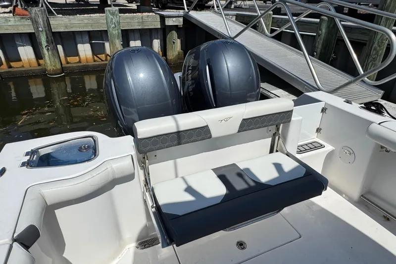 Slide: The Image of 2021 Tidewater 272 CC Adventure boat with dual engines and seating at dock. - 4