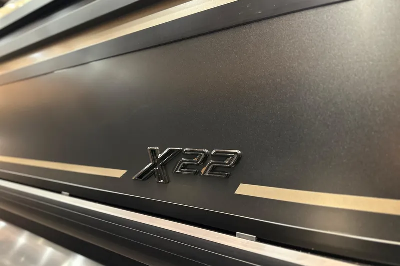 Slide: The Image of 2026 Viaggio Lago X22D Tritoon, sleek black exterior with "X22" emblem. - 22