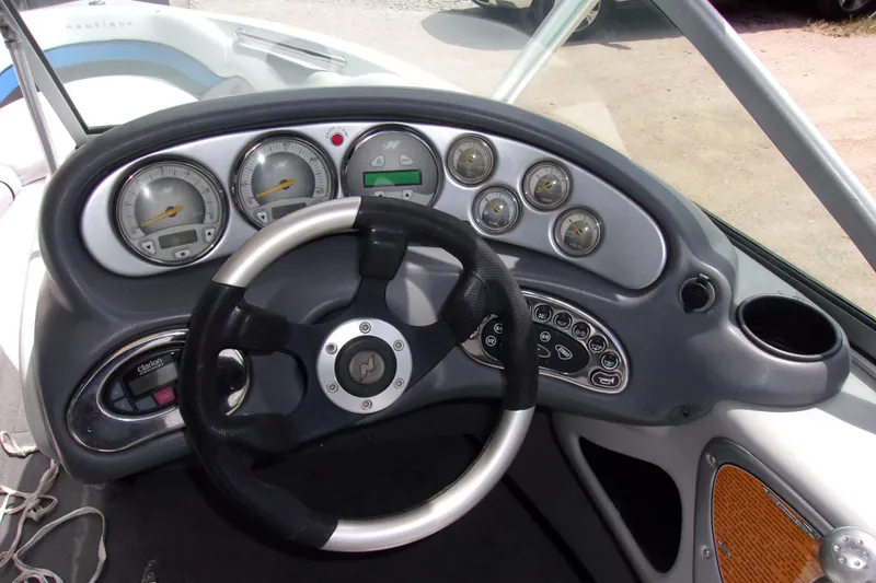 Slide: The Image of Dashboard of 2005 Correct Craft 210 SUPER AIR TEAM EDITION boat with steering wheel and gauges. - 4