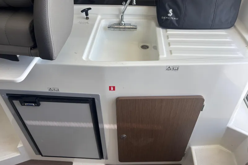 Slide: The Image of Interior of 2021 Beneteau Antares 8 with sink, fridge, and storage cabinet. - 10