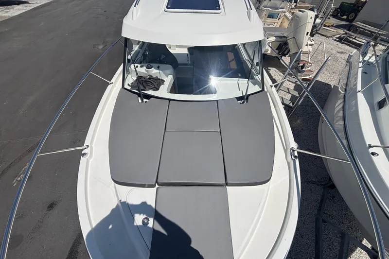 Slide: The Image of 2021 Beneteau Antares 8 boat with cushioned deck, docked in a marina. - 14