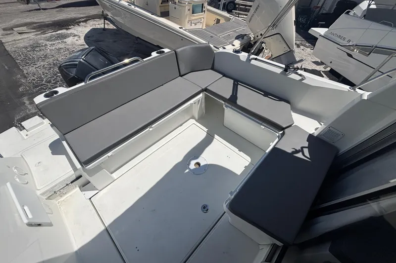 Slide: The Image of 2021 Beneteau Antares 8 boat deck with gray seating and storage compartments. - 4