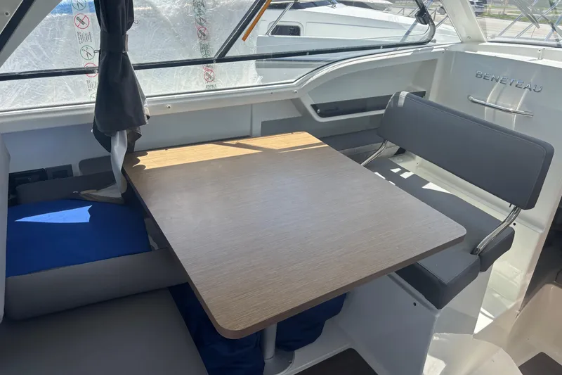 Slide: The Image of Interior of 2021 Beneteau Antares 8, featuring a wooden table and cushioned seating. - 8