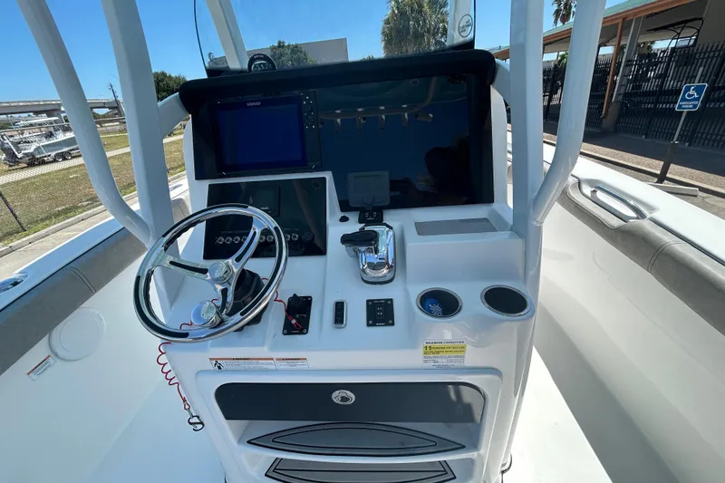 Slide: The Image of 2021 Sea Pro 239 Center Console boat dashboard with steering wheel and navigation equipment. - 12