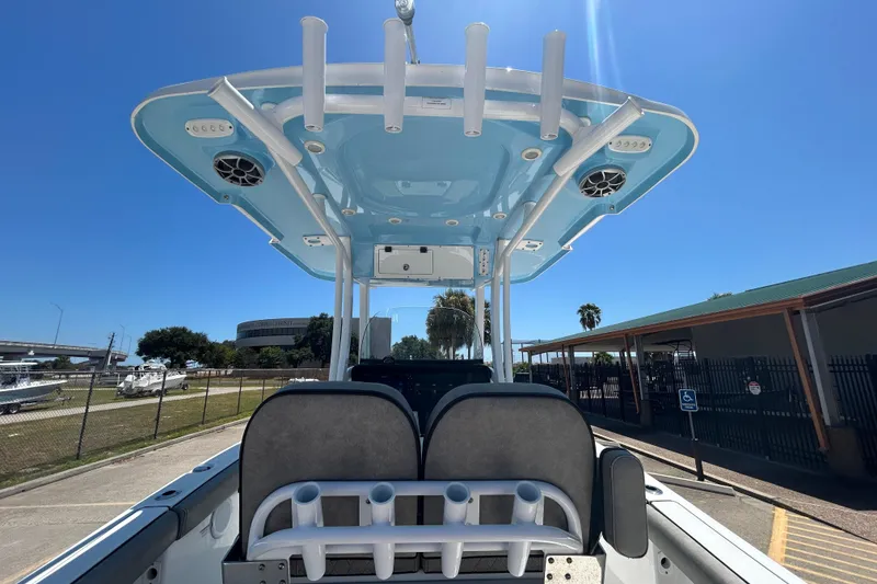 Slide: The Image of 2021 Sea Pro 239 Center Console boat with T-top and rod holders, parked outdoors. - 9