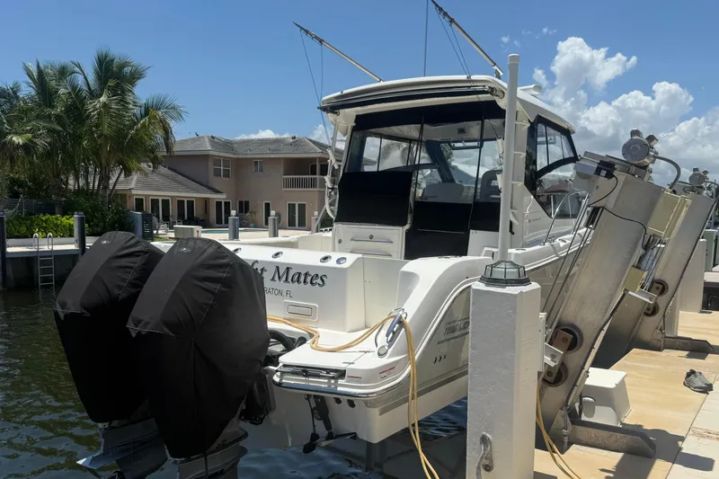 Slide: The Image of 2021 Boston Whaler 325 Conquest docked, featuring dual engines and a sleek design. - 1