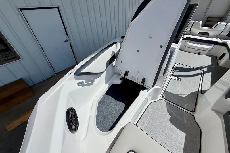 Slide: The Image of 2025 Yamaha Boats AR195 interior with open storage compartment and seating area. - 15