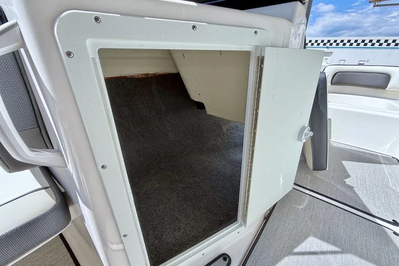 Slide: The Image of 2025 Yamaha AR195 boat storage compartment with open door, showcasing interior space. - 18