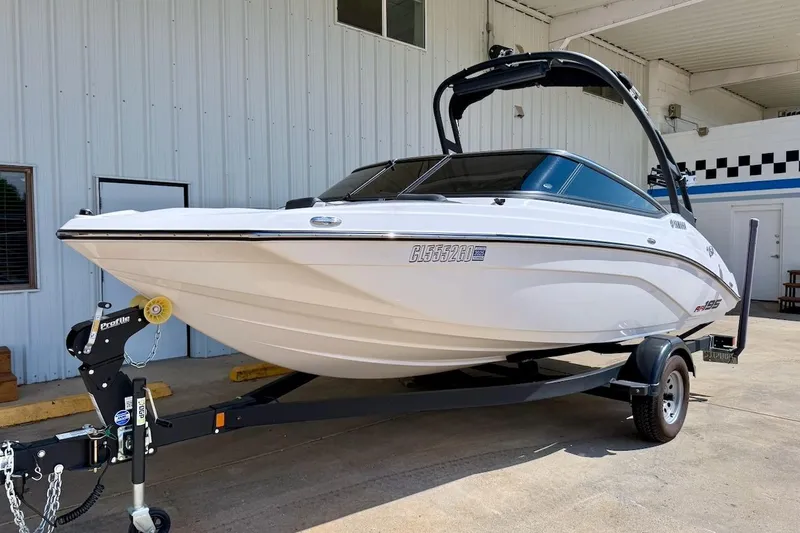 Slide: The Image of 2025 Yamaha Boats AR195 on trailer, parked outside a building. - 2