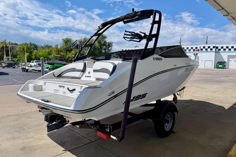 Slide: The Image of 2025 Yamaha Boats AR195 on trailer, parked outdoors under a clear sky. - 6