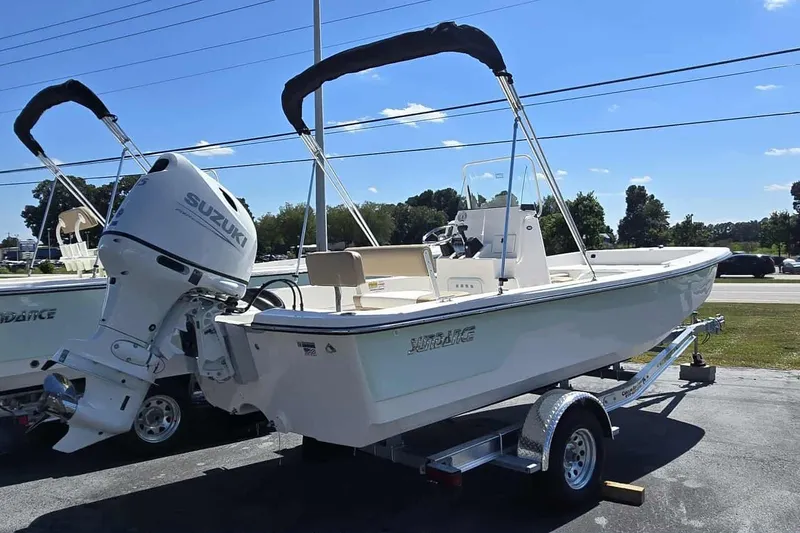Slide: The Image of 2026 Sundance B20CCR boat with Suzuki engine on a trailer, parked outdoors. - 2