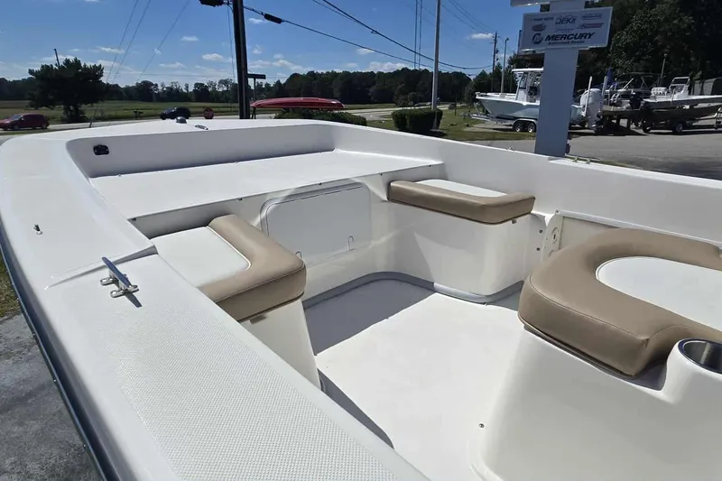 Slide: The Image of 2026 Sundance B20CCR boat interior with cushioned seating, outdoor display setting. - 7