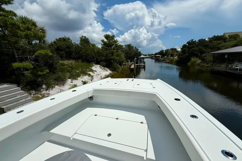 Slide: The Image of 2023 Freeman 34VH boat on a scenic river with lush greenery and cloudy sky. - 10