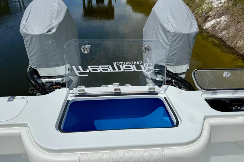 Slide: The Image of 2023 Freeman 34VH boat with covered engines and open livewell near water. - 13