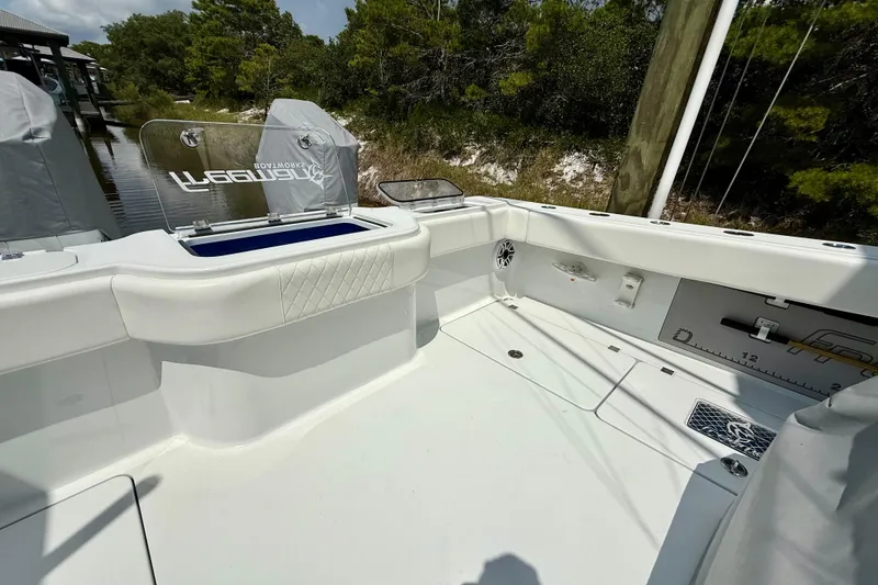 Slide: The Image of 2023 Freeman 34VH boat interior with seating and storage, docked near lush greenery. - 18
